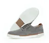A pair of grey casual shoes with brown accents, shown from a side angle with the sole of one shoe visible. Produktbild-Vorschau