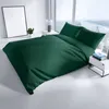 A neatly made bed with dark green bedding in a bright, modern room with large windows. Produktbild-Vorschau