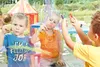 Three young children are drawing on a clear surface with crayons. Voir les images du produit