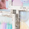 Close-up view of a multi-photo frame with a distressed white finish, showing portions of four different images within the frame. Produktbild-Vorschau