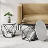 Two round coffee tables with black geometric bases and white marble-effect tops, placed in front of a tan sofa. Náhled obrázku produktu