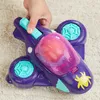 A hand holding a purple toy airplane with spider-themed details. Podgląd zdjęcia produktu