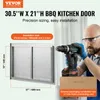A man is using a drill to install a stainless steel BBQ kitchen door. The image includes product dimensions and installation size information. Produktbild-Vorschau