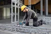 A man is working on a metal structure with a tool. Produktbild-Vorschau