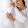 A woman is sleeping under a white blanket. Produktbild-Vorschau