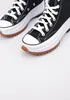 A close-up shot of a pair of black Converse Run Star Hike high-top sneakers with white laces and thick white platform soles, set against a plain white background. Náhled obrázku produktu