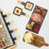 A raclette grill with various food items like cheese, meats, shrimp, and vegetables. Produktbild-Vorschau
