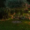 A garden at night with green and red lights projected onto the grass and trees. Anteprima dell’immagine prodotto