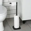 A toilet paper holder with two rolls of toilet paper next to a toilet in a bathroom. Podgląd zdjęcia produktu
