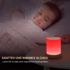 A baby sleeping peacefully next to a glowing LED lamp. Produktbild-Vorschau