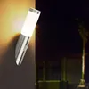 A modern outdoor wall lamp with a motion sensor, mounted on a wall at night. Produktbild-Vorschau