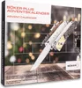 A close-up of a Böker Plus Advent Calendar box, featuring a knife and Christmas lights in the background. Náhled obrázku produktu