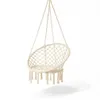 A cream-colored macrame hanging chair is suspended against a white background. Produktbild-Vorschau