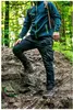 A person hiking up a rocky trail in a forest. Produktbild-Vorschau