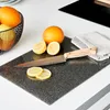 A cutting board with oranges and lemons on a kitchen counter. Náhled obrázku produktu