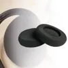 Two black foam ear pads for headphones are placed on top of a blurred image of headphones. Produktbild-Vorschau