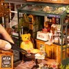 A miniature bistro scene with a teddy bear, food, and drinks. Voir les images du produit