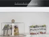 A close-up view of a refrigerator interior, showcasing desserts and a digital control panel. Podgląd zdjęcia produktu