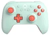 A mint green and coral colored game controller is shown from a front-facing, slightly elevated angle against a white background. Náhľad obrázku produktu