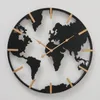 A black world map clock with gold accents against a white background. Podgląd zdjęcia produktu
