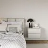 A bedroom scene featuring a bed and a nightstand. Produktbild-Vorschau