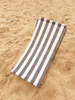 A striped beach chair lying on the sand. Produktbild-Vorschau
