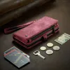 A red wallet phone case with a wrist strap is displayed on a brown surface, surrounded by coins, a key, and cards. Produktbild-Vorschau