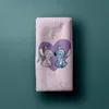 A pink towel with a Lilo and Stitch graphic is laid flat against a teal background. Produktbild-Vorschau