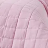 A close-up view of a pink quilted blanket. Produktbild-Vorschau