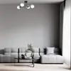 A modern living room with a gray sectional sofa and a coffee table in front of it. A ceiling light fixture is visible above. Podgląd zdjęcia produktu