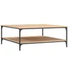 A square coffee table with two shelves, made of wood-look material and black metal legs, shown against a white background. Produktbild-Vorschau