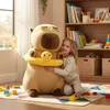 A young girl hugging a large capybara plush toy in a child's room with toys and books. Anteprima dell’immagine prodotto