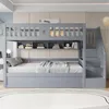 A gray bunk bed with a pull-out trundle bed, shelves, and stairs in a bedroom setting. Produktbild-Vorschau