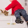 A child is playing with a wooden toy on a white surface, with a child safety lock visible. Voir les images du produit