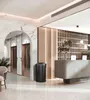 A modern lobby with elevators, a reception desk, and a trash can. Podgląd zdjęcia produktu