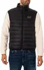 A man wearing a black puffer vest over a beige long-sleeved shirt and blue jeans. Produktbild-Vorschau