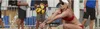 A woman playing beach volleyball, in the process of hitting the ball. Podgląd zdjęcia produktu