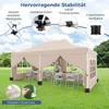 A beige pop-up tent set up on a grassy lawn with tables and chairs inside, showcasing its stability features. Produktbild-Vorschau