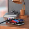 A desk with a wireless charger, smartphone, smartwatch, books, and a lamp. Produktbild-Vorschau