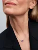 Close-up of a woman wearing a necklace with two heart-shaped pendants. Produktbild-Vorschau