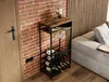 A wine rack is placed next to a brick wall and a sofa in a living room. Podgląd zdjęcia produktu