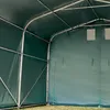 Interior view of a green tent or shelter with metal framing. Voir les images du produit