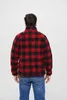 A person seen from behind wearing a red and black checkered jacket and blue jeans. Produktbild-Vorschau