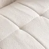 A close-up view of a textured, beige sofa cushion with a bouclé surface. Voir les images du produit