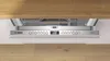 The top control panel of a built-in dishwasher, with the door slightly ajar. Produktbild-Vorschau