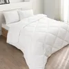 A white comforter and two pillows are neatly arranged on a bed with a wooden frame. Produktbild-Vorschau
