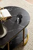 A close-up view of a marble-look coffee table with a book and a glass on it, placed on a textured rug. Náhled obrázku produktu