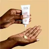 A person's hands are shown, with one hand holding a tube of SVR Cicavit+ Creme SPF50+ and dispensing the cream into the palm of the other hand. Náhled obrázku produktu