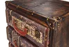 A close-up view of a vintage-style chest of drawers designed to look like stacked suitcases. Podgląd zdjęcia produktu