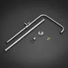 A set of shower system accessories, including a shower arm, extension pipe, and mounting hardware, laid out on a dark gray background. Podgląd zdjęcia produktu
